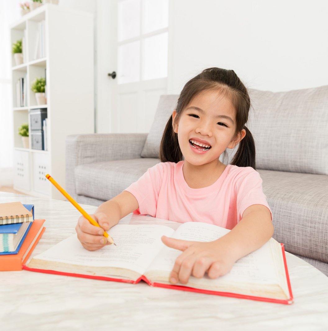 A kid engaged in reading and writing activities